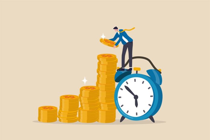 Long term investing or savings for retirement fund, compound interest or investment growth, tax time reminder concept, businessman on alarm clock put more dollar coin money to increase his savings. APM firma nova parceria para o serviço de contabilidade aos associados